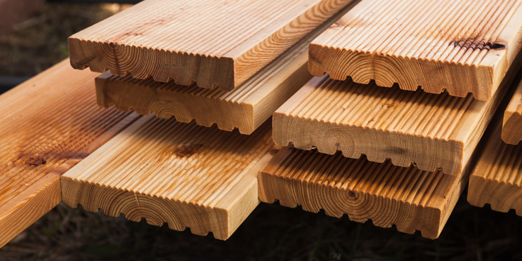 Mehrere Terrassendielen auf einem Stapel mit geriffelter Oberfläche und genuteter Unterseite